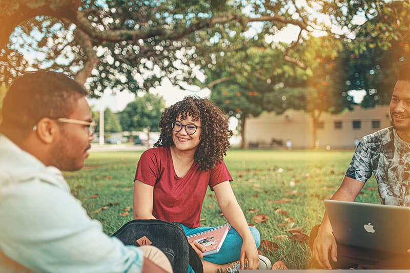 Group of students sitting outside in grass