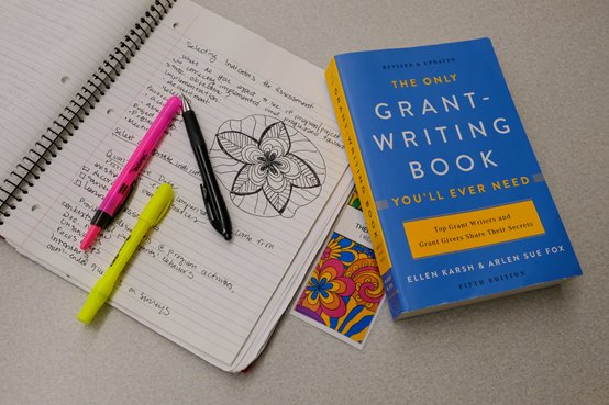 Notepad and book about grant writing