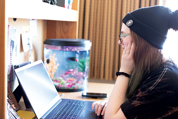 Student in her room, working on a laptop