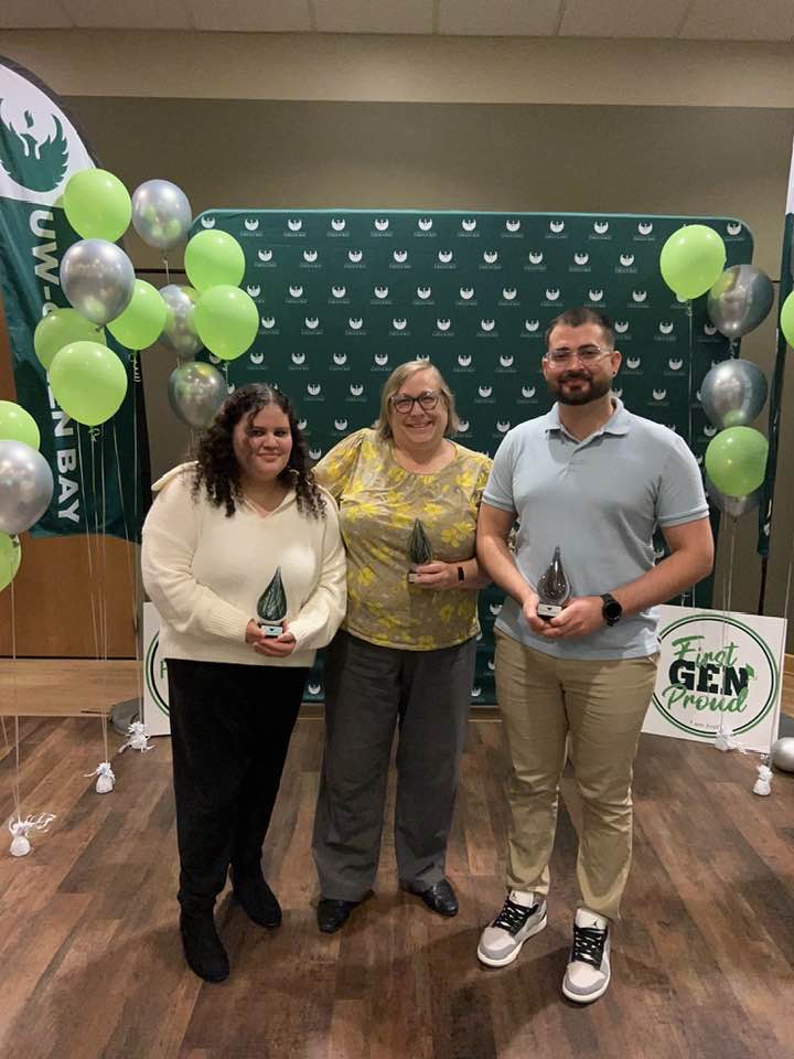 Three people holding awards
