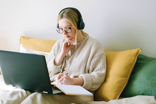 Student taking notes during online class