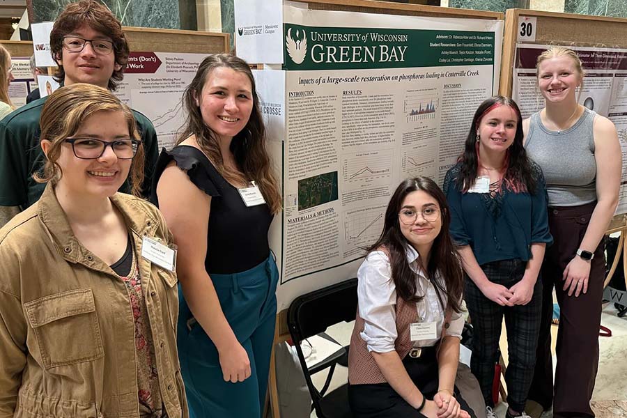 Group of students in front of large research poster