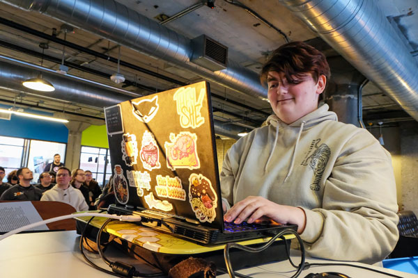 Student working at laptop covered in colorful stickers