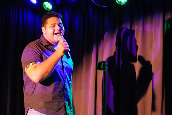 Male student singing on stage at Phoenix Club