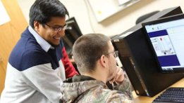 UW-Green Bay's Md Maruf Hossain assisting an engineering tech student at a computer.
