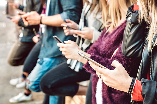 Row of people checking their devices