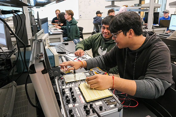lectrical Engineering students use an oscilloscope, function generator and training board to test transient response of RL circuit with step inputs during Electrical Circuits II Lab inside the TEAMS IS-1067 Electronics Circuits Lab at UW-Green Bay