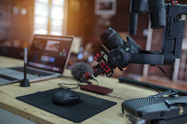 A high-quality camera, microphone, and laptop on a desk.