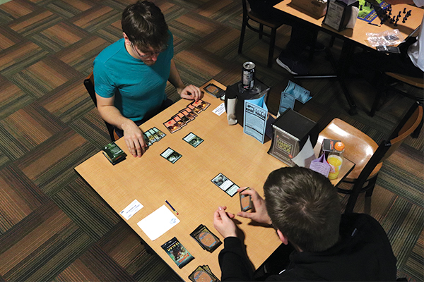 Two students play Magic The Gathering.