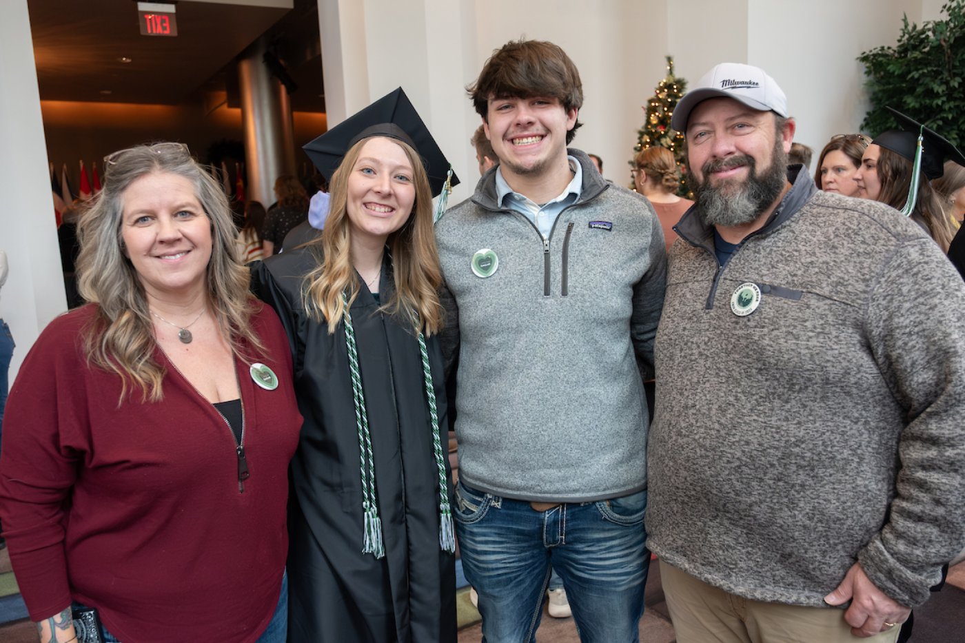 A family of four, including a recent UW-Green Bay graduate, pose for a photo after a Commencement ceremony.