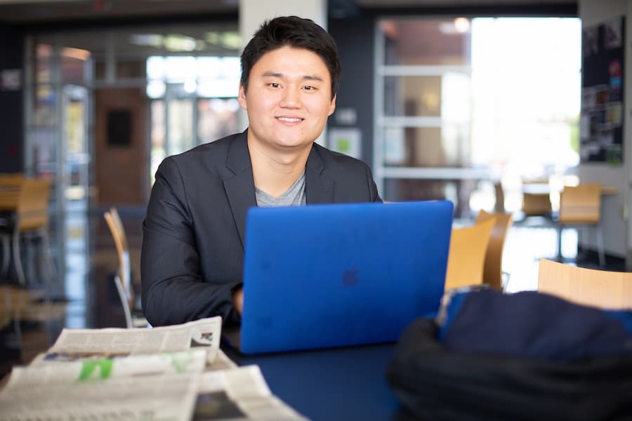 UWGB online business student working on laptop