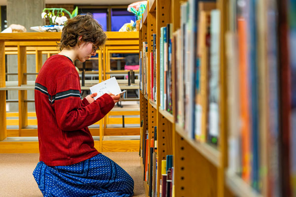 Student looking through books in library