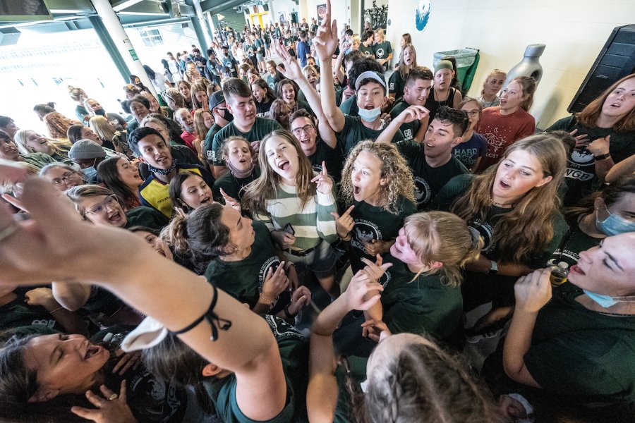 A large crowd of students gather at Lambeau Field for their civic engagement celebration in September 2021. Many students have their hands up and are dancing to music.