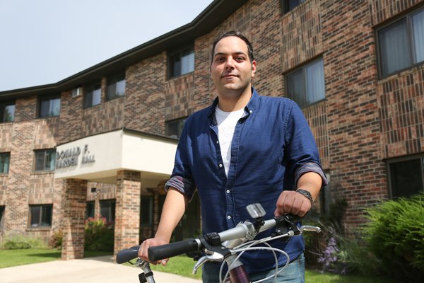 Student on bike in front of housing