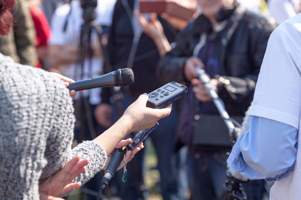 Reporters with microphones and recorders