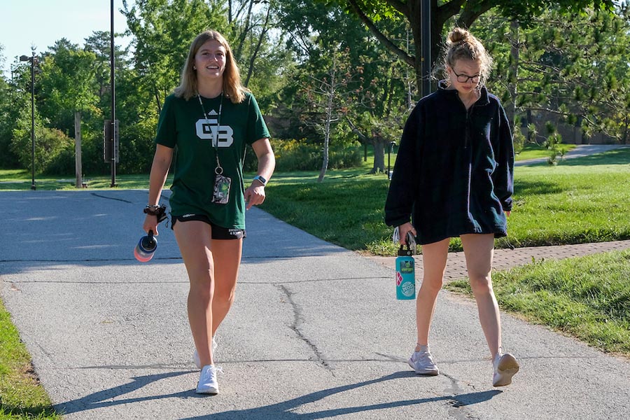 Two students walking on campus path