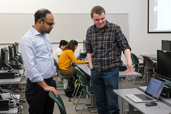 Professor working with student in computer lab