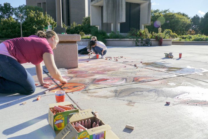 Students drawing with sidewalk chalk
