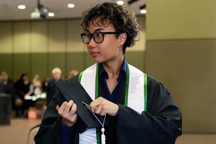 Student in graduation robe, holding cap
