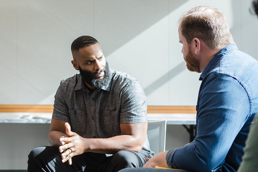 two men talking during group therapy