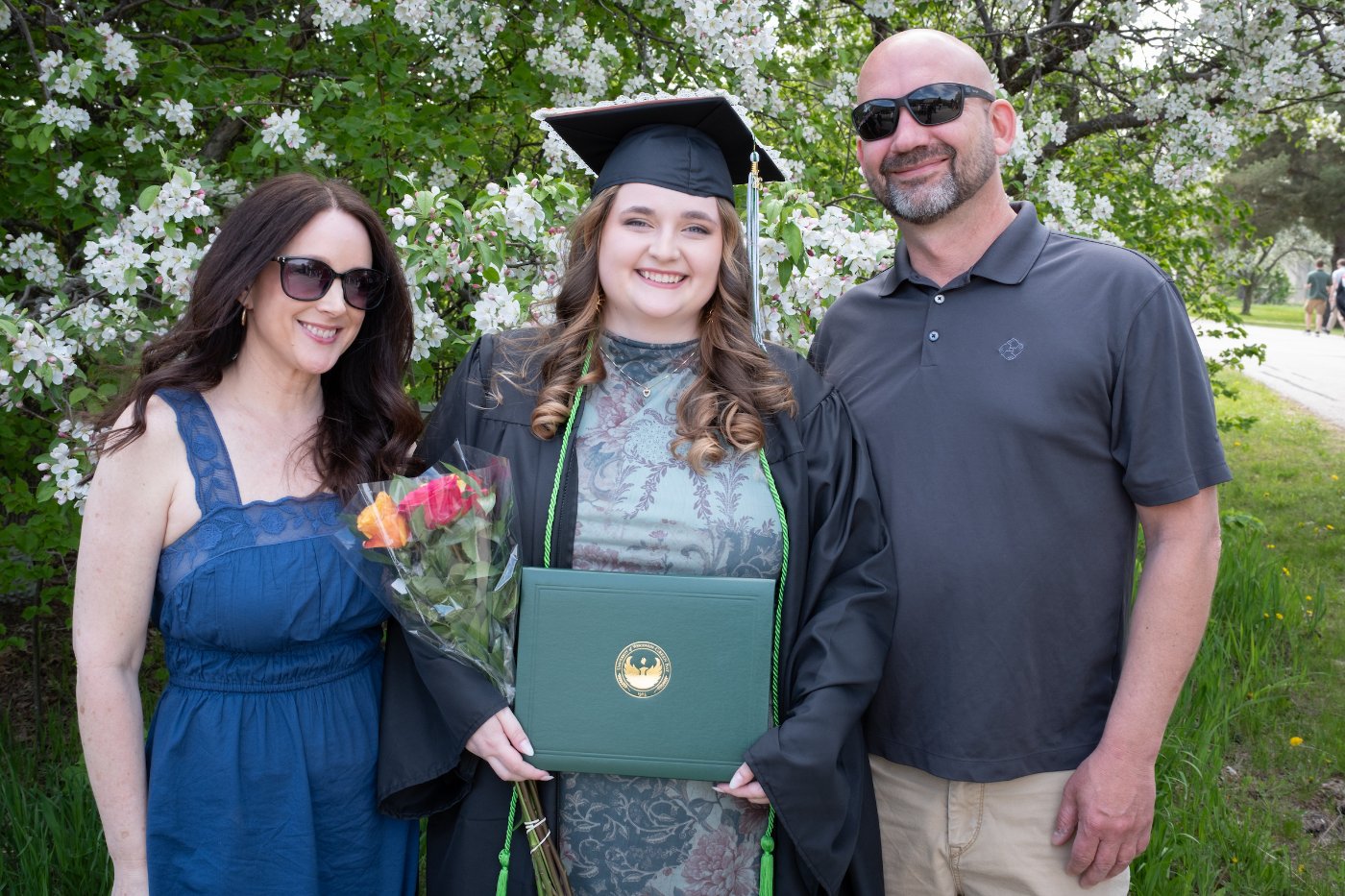 graduate poses with family at commencement.