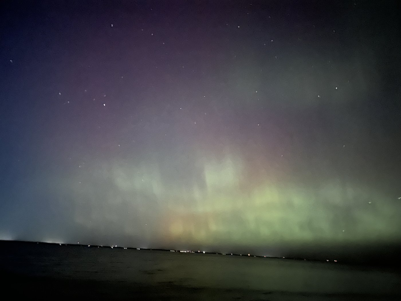A photo of the Northern Lights over a bay..