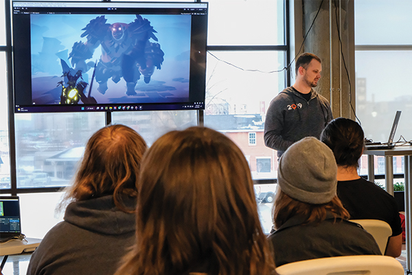 A student-made video game being displayed in front of a group.