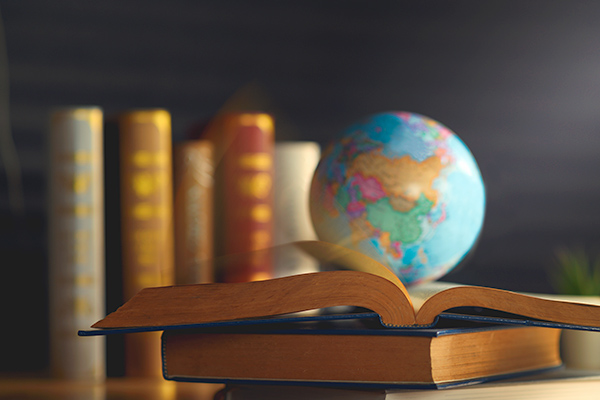 Globe on open book with more books in background