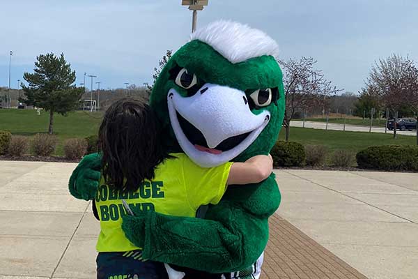 Phlash Mascot hugging student