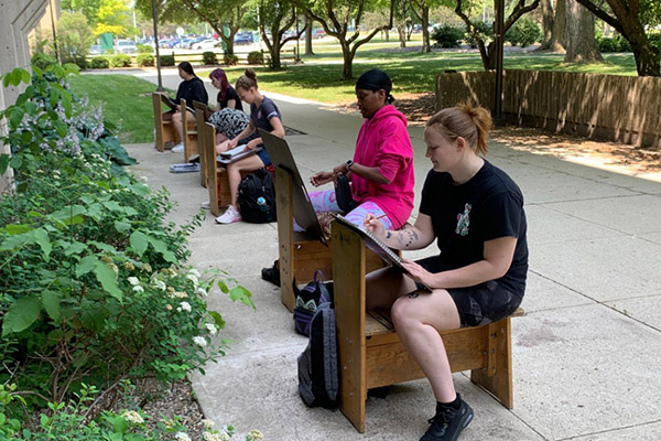 Students outside on drawing horses on walkway