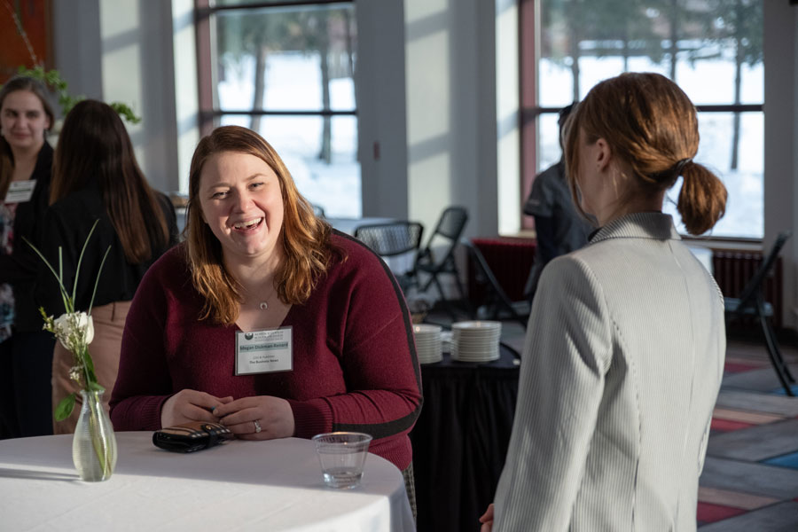 Two women converse at event