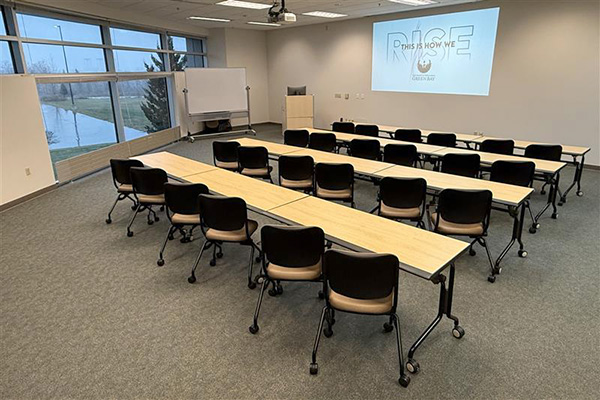 Conference room with tables, chairs and projection on front wall