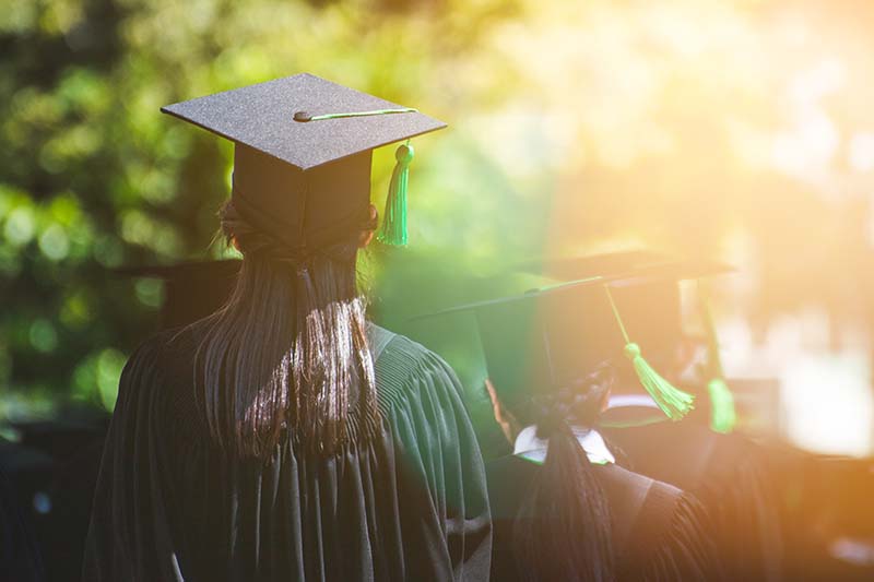 rear view of graduates walking outside