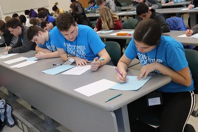 Students writing at a desk