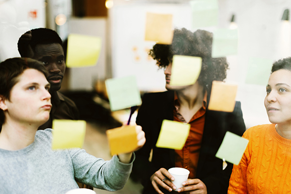 Diverse group of people in front of wall with sticky notes