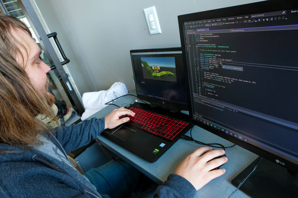 Man working with laptop and extra monitor