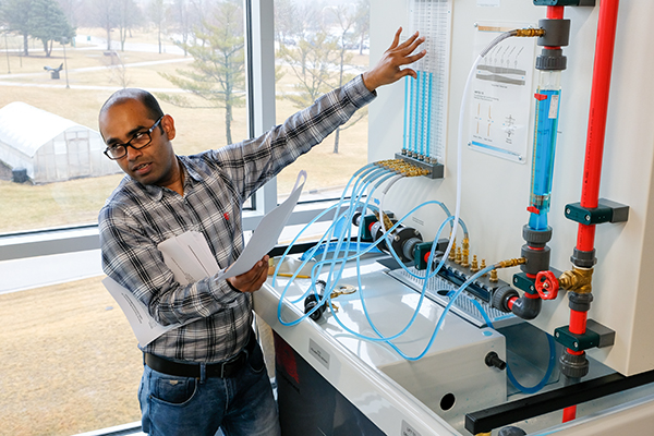 an instructor gesturing towards an apparatus in the STEM innovation center