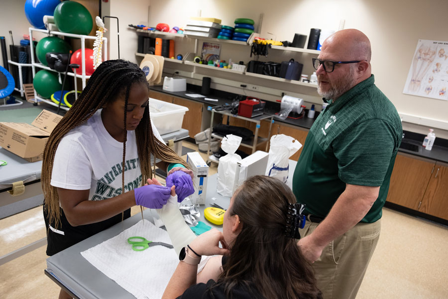 Professor teaches students proper wrist taping