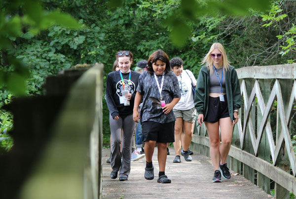 Campers walking over bridge outside