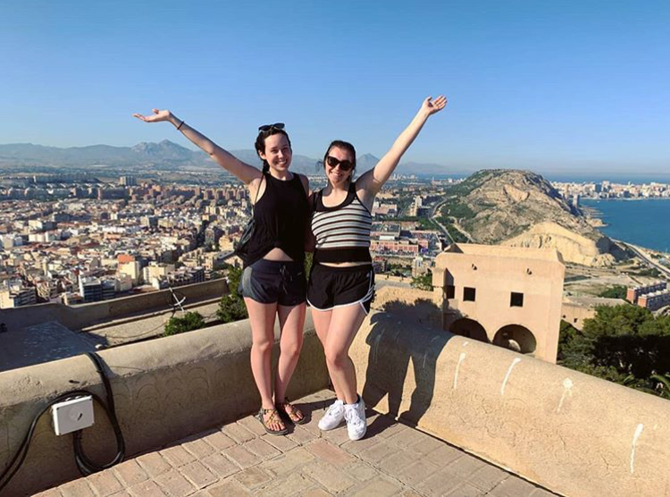 Two people posing in front of a cityscape