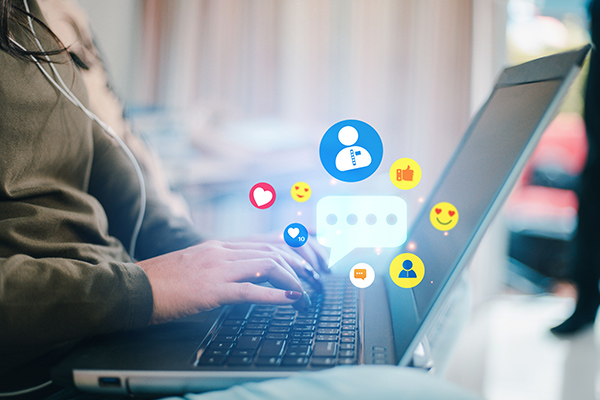 Person with laptop and social media references
