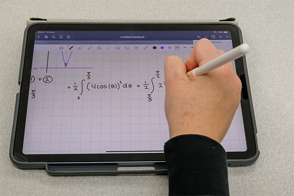 Students taking calculus notes on a tablet
