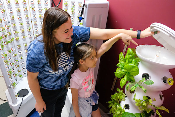 Intern shows child indoor gardening