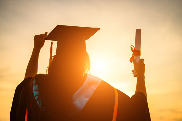 Graduate holds diploma in the sunlight