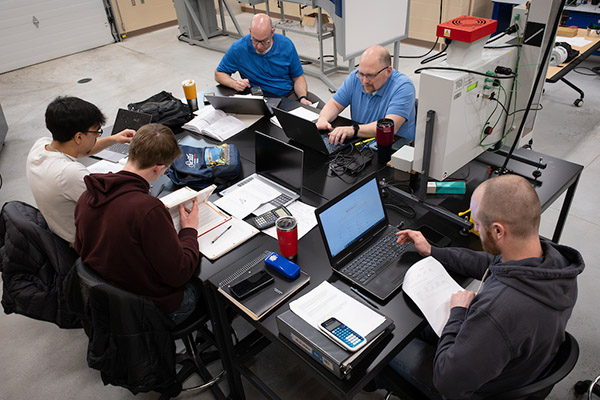 Overhead shot of table with engineering students working