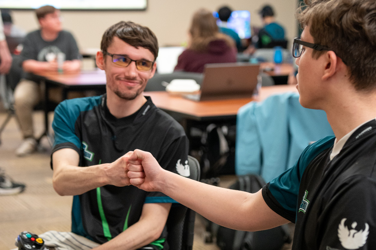 Two Esports team members share a fist bump