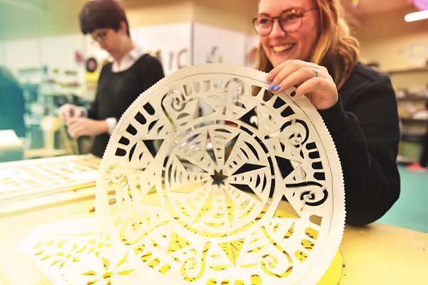 Student holding paper art project