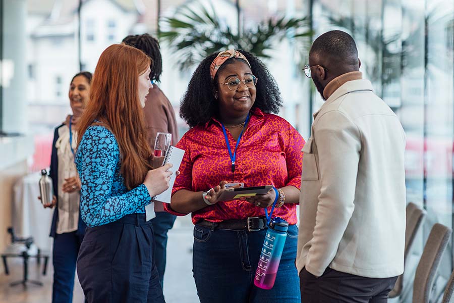 group of three people talking during a work networking event