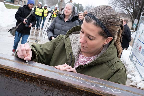 UWGB staff member signing an iron I-beam at CTEC topping out ceremony