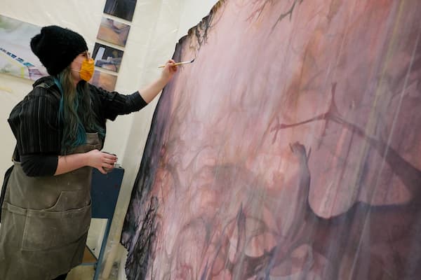student works on large painting